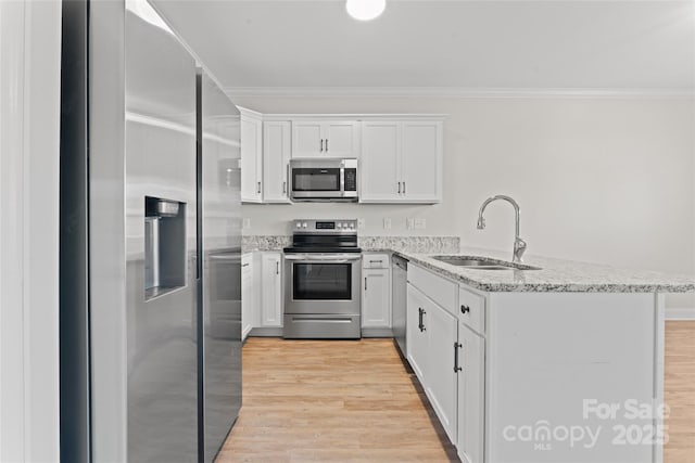 2032 Summey Ave, Charlotte, NC 28205 - kitchen with stainless steel appliances, a sink, a peninsula, white cabinetry, and ornamental molding