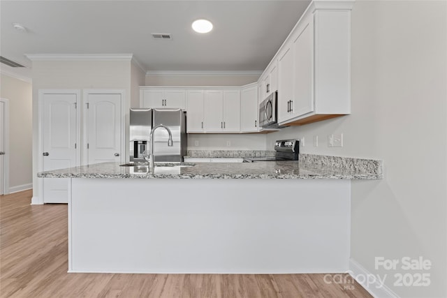 2032 Summey Ave, Charlotte, NC 28205 - kitchen featuring stainless steel appliances, crown molding, light stone countertops, a sink, and white cabinetry