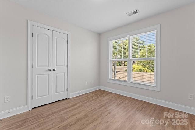 2032 Summey Ave, Charlotte, NC 28205 - unfurnished bedroom featuring light wood-type flooring, baseboards, and a closet