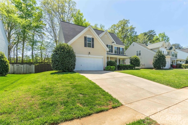 traditional home featuring fence, a front lawn, driveway, and a garage