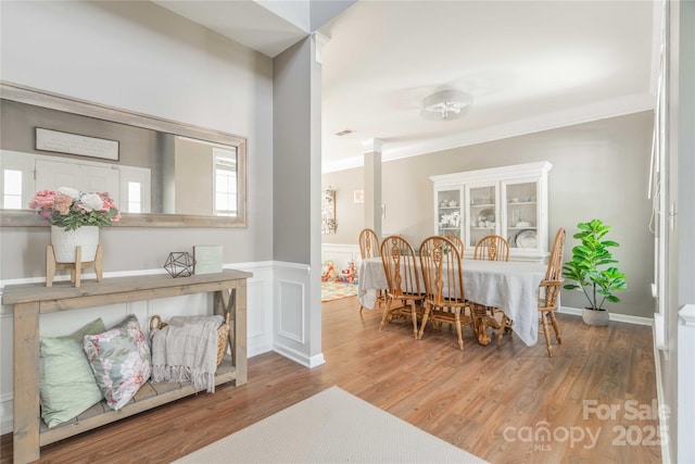 dining space featuring crown molding and wood finished floors