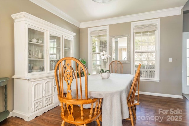 dining space with crown molding, baseboards, and wood finished floors