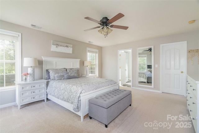 bedroom featuring baseboards, visible vents, light carpet, and multiple windows
