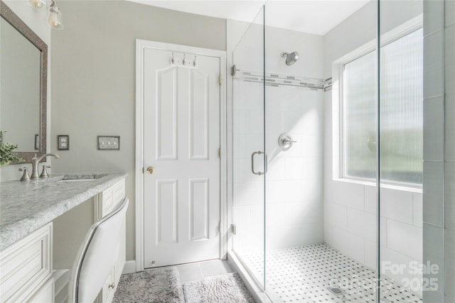 bathroom with vanity, a shower stall, and plenty of natural light