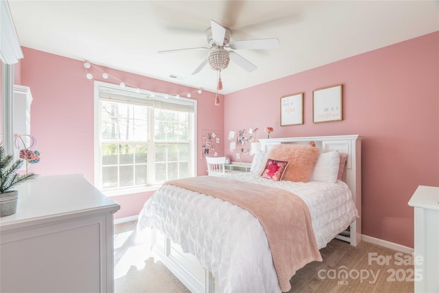 bedroom featuring baseboards, visible vents, light carpet, and ceiling fan