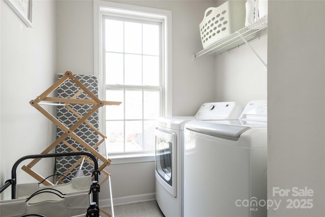 laundry room featuring baseboards, light tile patterned floors, laundry area, and washer and clothes dryer