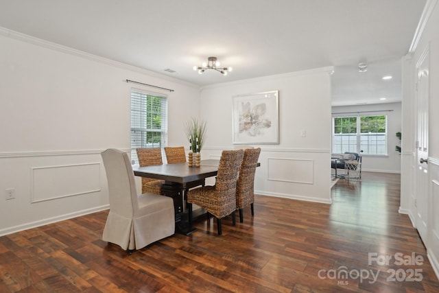dining space featuring crown molding, an inviting chandelier, and a decorative wall