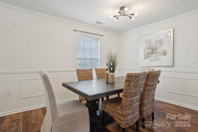 dining space featuring wood finished floors, visible vents, crown molding, and a notable chandelier