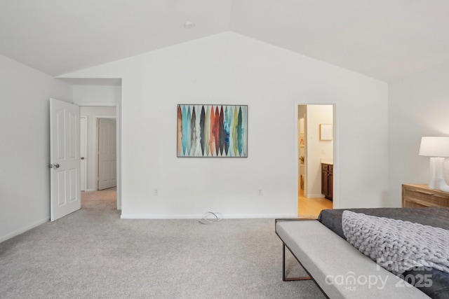 bedroom with lofted ceiling, light colored carpet, and baseboards