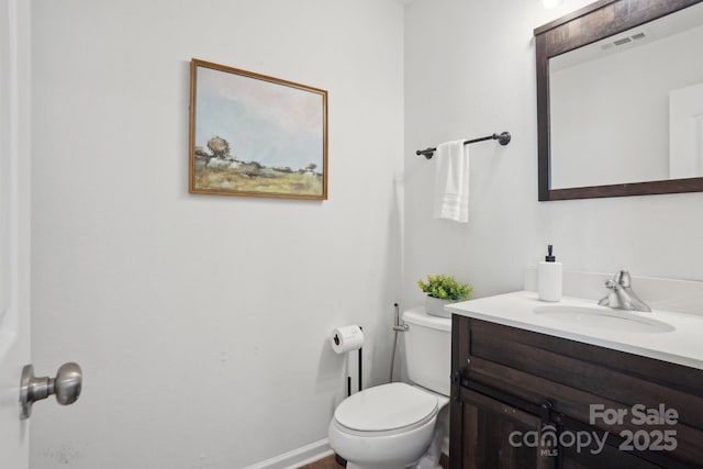 bathroom featuring visible vents, toilet, and vanity