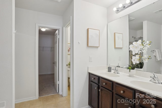 bathroom with double vanity, a sink, tile patterned floors, and visible vents