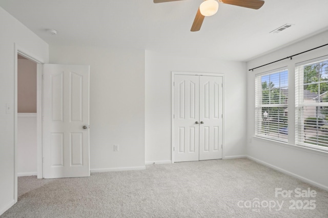 unfurnished bedroom with a closet, carpet flooring, visible vents, and baseboards