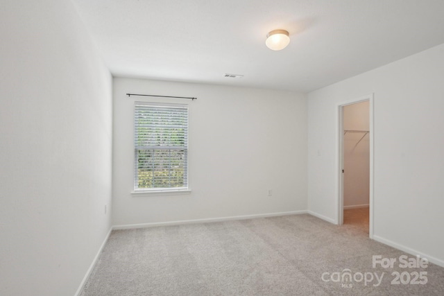 unfurnished room featuring visible vents, light carpet, and baseboards