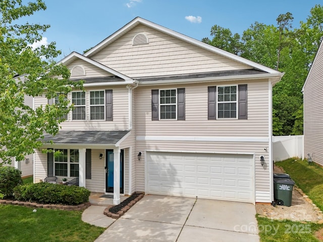 traditional-style home with fence, a porch, driveway, and an attached garage