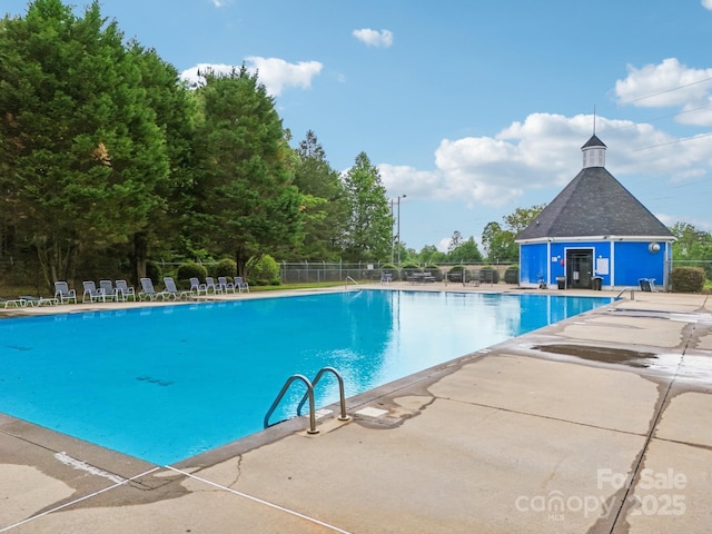 pool featuring fence and a patio area