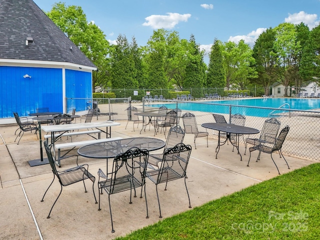 community pool featuring fence and a patio area