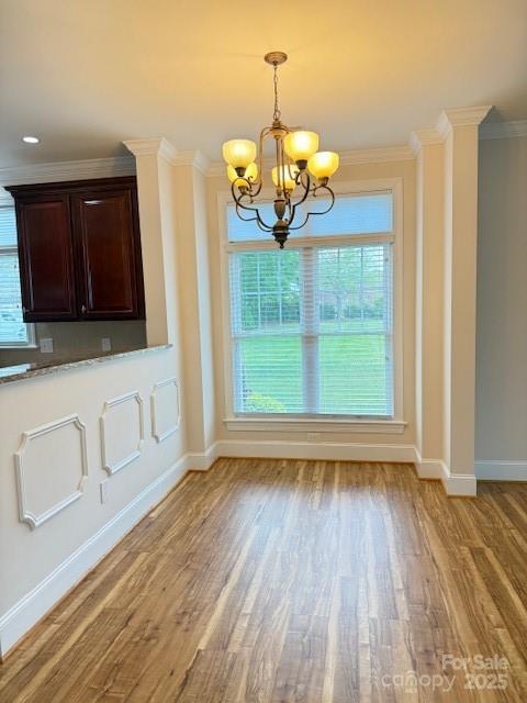 216 Harrison Ln Unit 4, Locust, NC 28097 - unfurnished dining area with ornamental molding, a notable chandelier, baseboards, and light wood-style floors