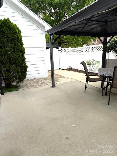 216 Harrison Ln Unit 4, Locust, NC 28097 - view of patio featuring fence, a gazebo, and outdoor dining space