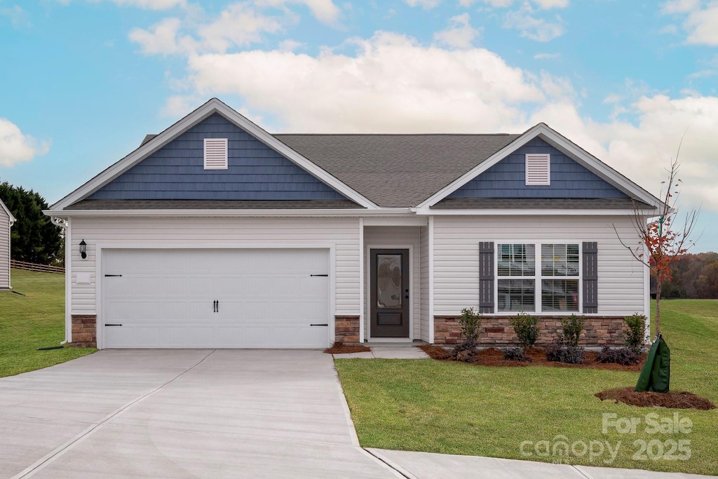 craftsman-style house with a garage, roof with shingles, stone siding, a front lawn, and driveway