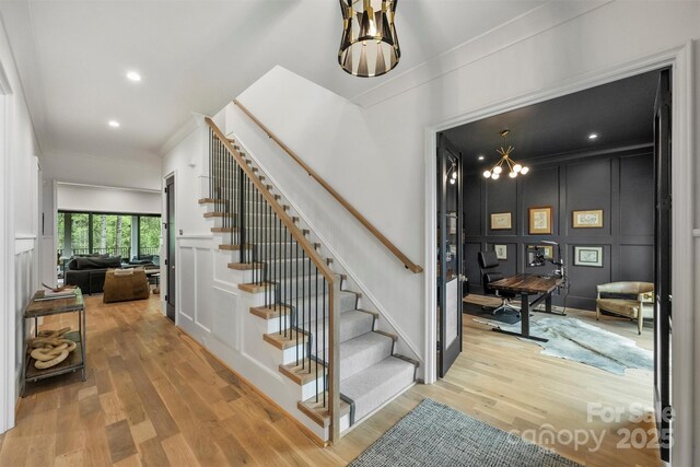 438 Wonderwood Dr, Charlotte, NC 28211 - staircase featuring a decorative wall, ornamental molding, recessed lighting, a chandelier, and wood finished floors