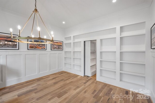 438 Wonderwood Dr, Charlotte, NC 28211 - below grade area with ornamental molding, built in features, a notable chandelier, and wood finished floors