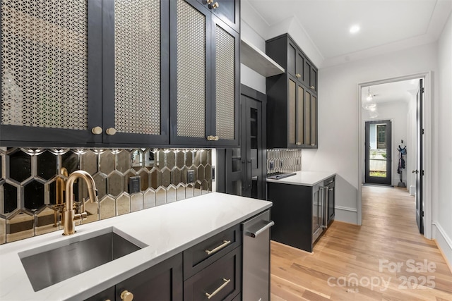 438 Wonderwood Dr, Charlotte, NC 28211 - kitchen featuring baseboards, light wood-style flooring, crown molding, decorative backsplash, and a sink