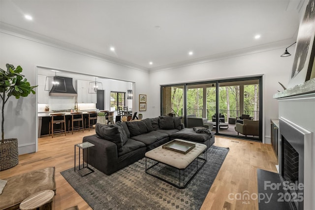 438 Wonderwood Dr, Charlotte, NC 28211 - living area featuring ornamental molding, recessed lighting, light wood-style floors, and a fireplace with flush hearth