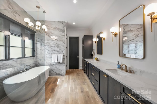 438 Wonderwood Dr, Charlotte, NC 28211 - bathroom with a freestanding bath, double vanity, a sink, and wood finished floors
