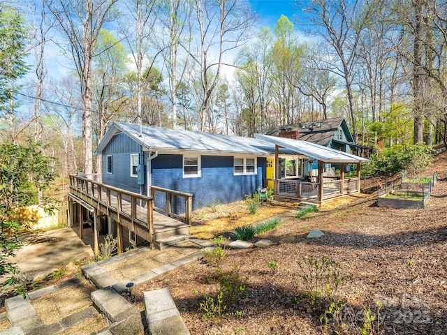 view of front of property featuring a wooden deck and brick siding