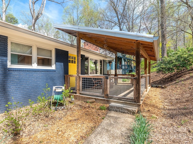 property entrance with brick siding and a porch