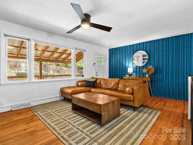living area featuring visible vents, a ceiling fan, and hardwood / wood-style flooring