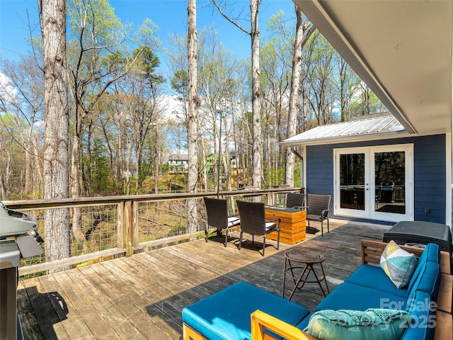 wooden terrace with french doors, grilling area, outdoor dining area, and an outdoor hangout area