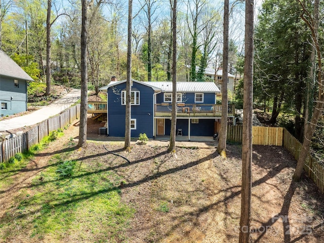 rear view of property featuring a fenced backyard and a wooden deck
