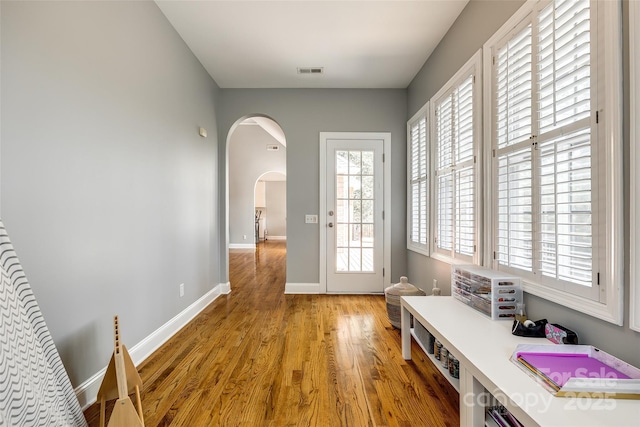 1126 Blowing Rock Cv, Fort Mill, SC 29708 - doorway to outside featuring light wood-style floors, arched walkways, visible vents, and baseboards