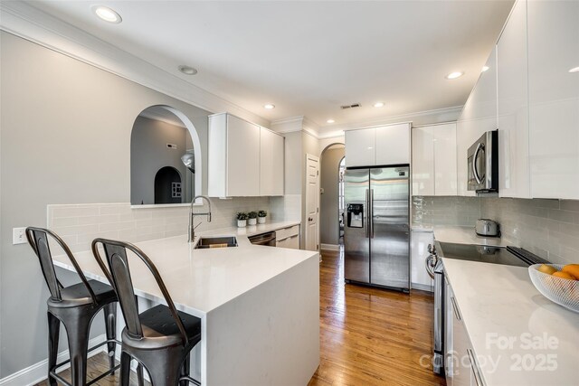 1126 Blowing Rock Cv, Fort Mill, SC 29708 - kitchen with a kitchen bar, tasteful backsplash, arched walkways, a sink, and stainless steel appliances