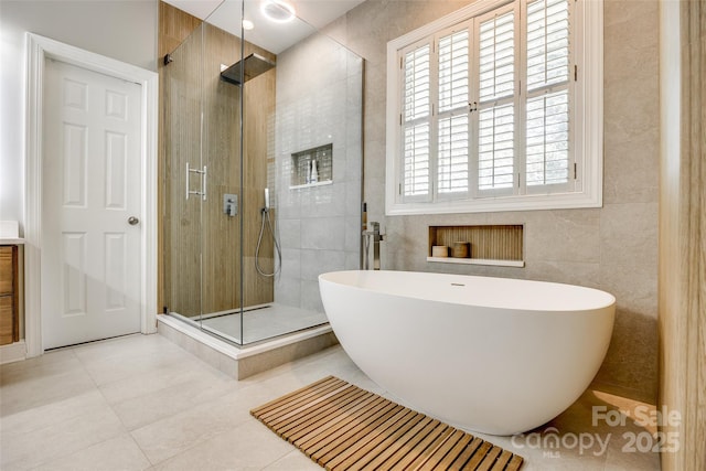 1126 Blowing Rock Cv, Fort Mill, SC 29708 - bathroom with a shower stall, a freestanding tub, tile walls, and tile patterned flooring