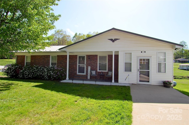 view of front facade with brick siding and a front lawn