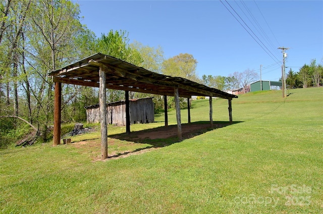 view of yard featuring a carport and an outdoor structure
