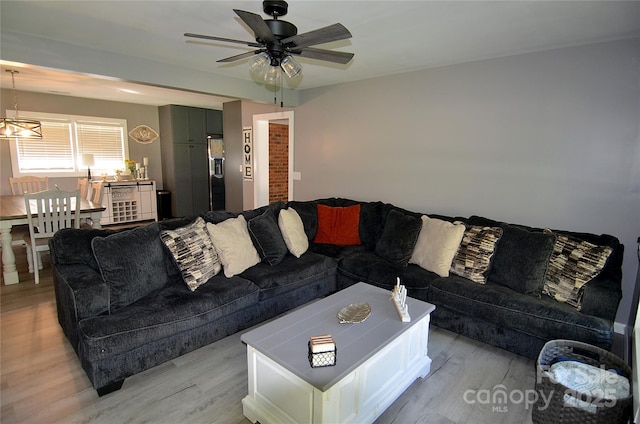 living room featuring light wood finished floors, a ceiling fan, and beverage cooler