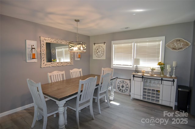 dining room with visible vents, baseboards, and wood finished floors