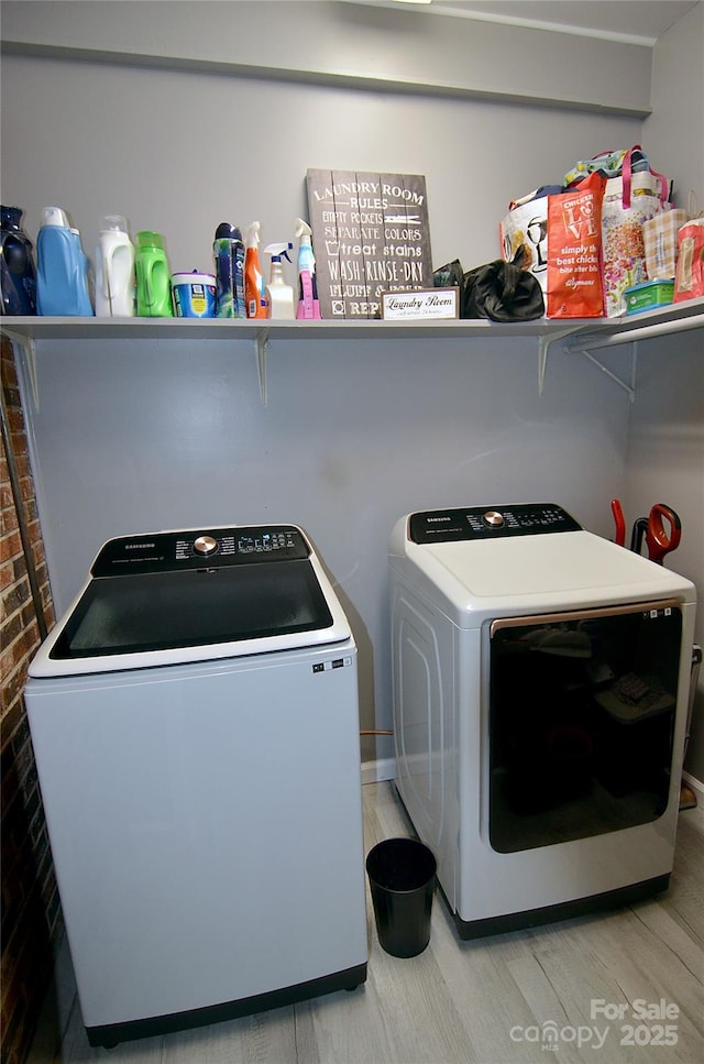 washroom with light wood-style flooring, laundry area, and washing machine and dryer