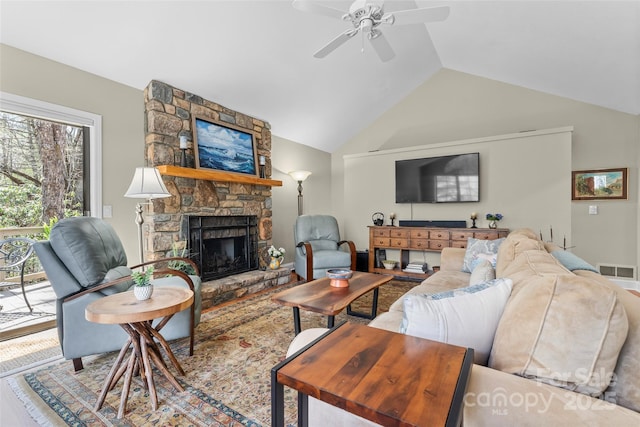 living area with wood finished floors, visible vents, a fireplace, high vaulted ceiling, and ceiling fan