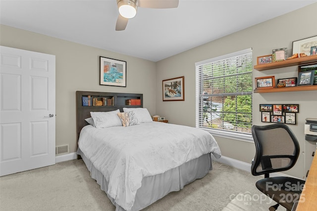 bedroom featuring visible vents, a ceiling fan, baseboards, and light carpet
