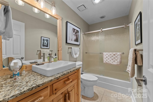 bathroom with combined bath / shower with glass door, vanity, tile patterned flooring, and toilet