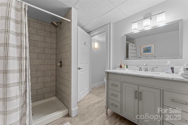 full bathroom with baseboards, vanity, and a stall shower