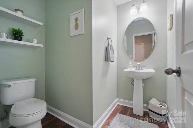 bathroom with wood finished floors, toilet, and baseboards