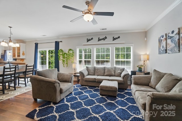 living area with ceiling fan, crown molding, wood finished floors, and visible vents