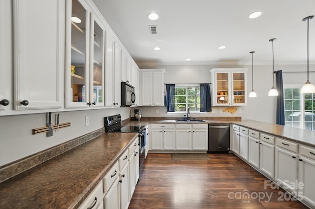 kitchen featuring white cabinets, a sink, visible vents, crown molding, and black appliances