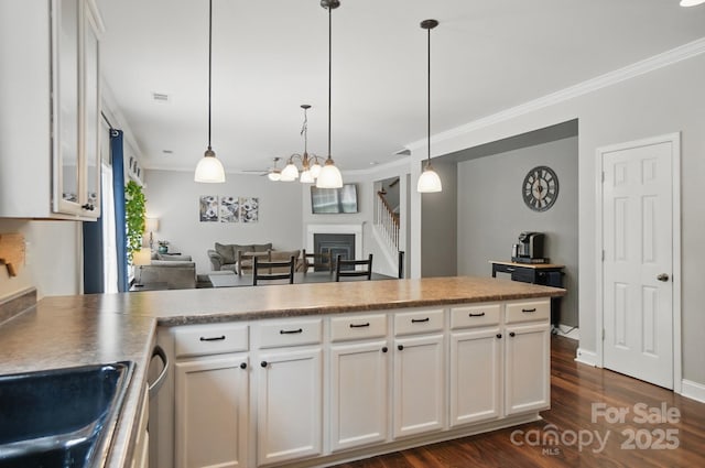 kitchen featuring ornamental molding, a peninsula, and dark wood-type flooring