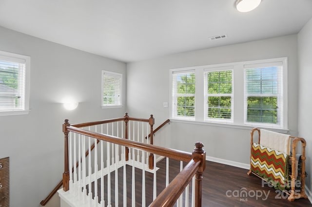 stairway with baseboards, wood finished floors, and visible vents